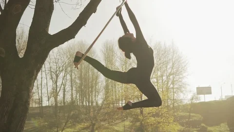 Woman doing some acrobatic elements on aerial hoop outdoors Stock Footage 104766269