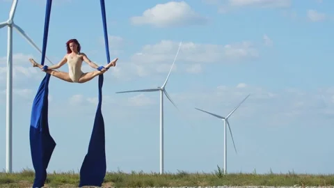 Woman is doing a split between two strings of fabric, aerial acrobatics, 4k Stock Footage 143246621