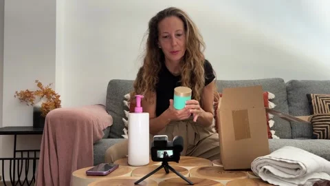 Woman doing an unboxing while filming content Stock Footage 342498341