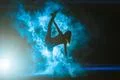 The woman doing vertical split in the smoke on the bright light background Photo