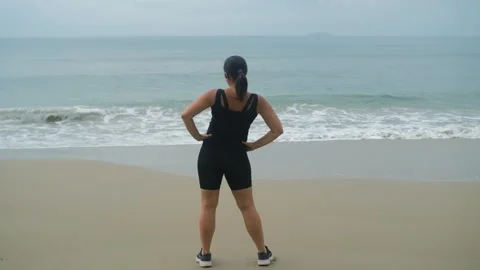 Woman doing warm-up exercises on sandy beach Stock-Footage 335255782