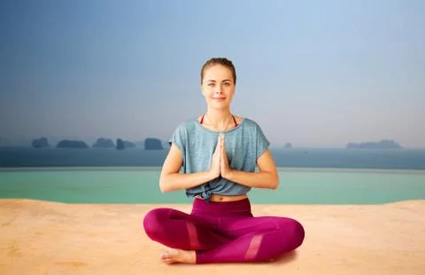 Woman doing yoga and meditating in lotus pose Stock Photos