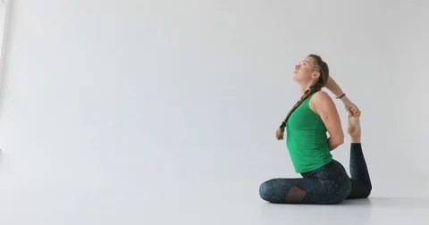 Woman doing a yoga exercise. Yoga in the light studio. Harmonious people Stock Footage