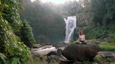 Woman doing yoga (Kapalbhati) in front of Tegenungan Waterfall, Ubud Video stock 65226053