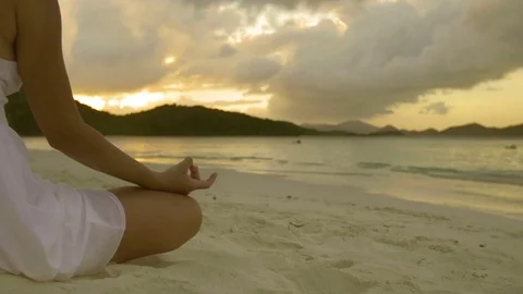 Woman doing yoga meditation on tropical beach at sunset Stock Footage