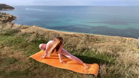 Woman doing yoga by the sea Stock Footage 166320431