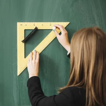 Woman drawing with triangular ruler blackboard Fotos de archivo
