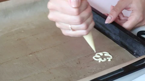A woman draws a dough pattern on a baking sheet. The process of making Swiss  Stock Footage 133061359