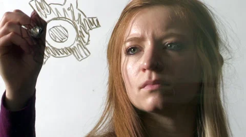 Woman Draws Interlocking Cogs on a Pane of Glass Stock Footage 61480178