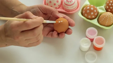 A woman draws a pattern on Easter eggs. Stock Footage 181027628