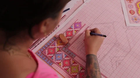 Woman draws a sketch on paper. Multi-colored patterns on a large sheet of paper. Stock Footage 122009853