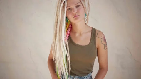 Woman with dreadlocks looking at camera touching her hair Stock Footage 139299727