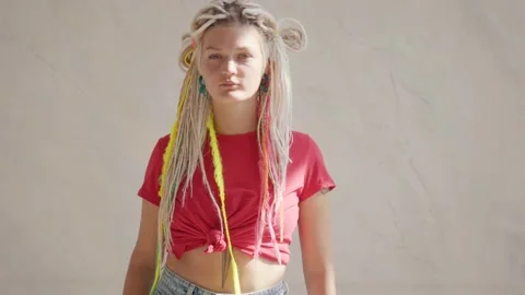 Woman with dreadlocks looking at camera touching her hair Stock Footage 139299848