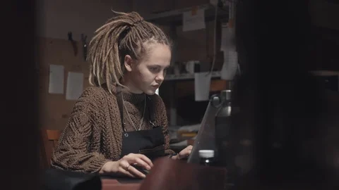 Woman with dreadlocks looking for examples for inspiration in laptop Vidéo 124520024
