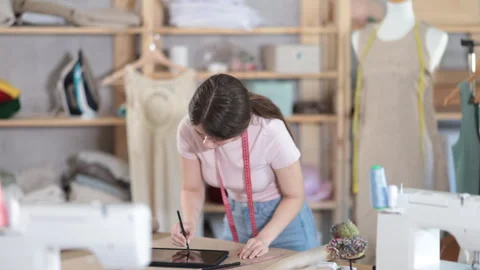 Woman dressmaker makes pattern using tablet Stock Footage 317999228