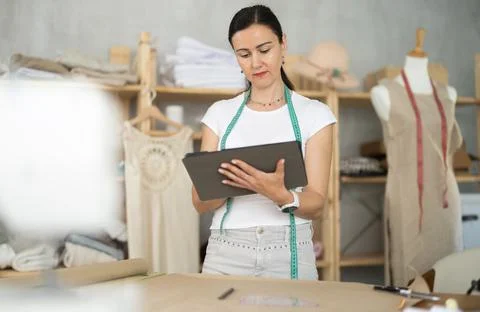Woman dressmaker makes pattern using tablet Stock Photos