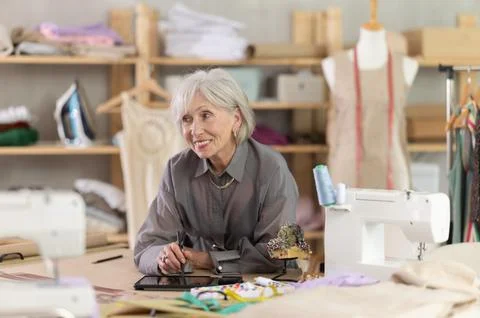 Woman dressmaker makes pattern using tablet Stock Photos