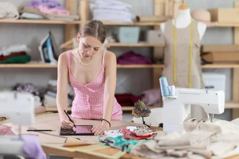 Woman dressmaker makes pattern using tablet Stock Photos