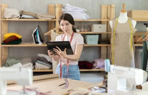 Woman dressmaker makes pattern using tablet Stock Photos