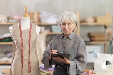 Woman dressmaker makes pattern using tablet Stock Photos