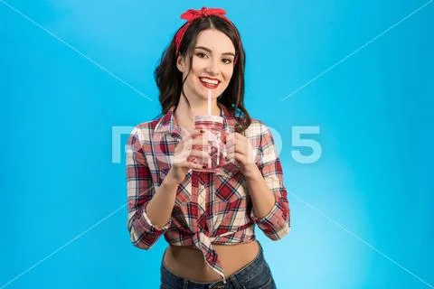 The woman with a drink standing on the blue background Stock Photos