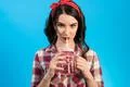 The woman drinking a beverage on the blue background Photo