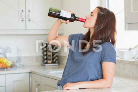 Woman drinking a bottle of wine alone Stock Photos