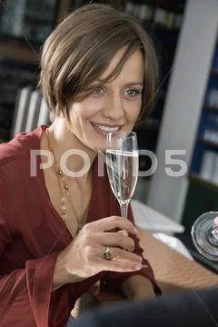 A woman drinking champagne in bar Stock Photos