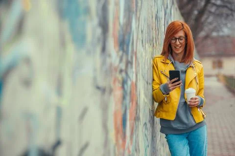 Woman drinking coffee and using smartphone Stock Photos