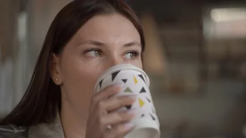 Woman drinking coffee in a cafe while waiting for a meeting with a partner Video stock 141425721