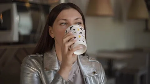 Woman drinking coffee in a cafe while waiting for a meeting with a partner Stock Footage 141425801