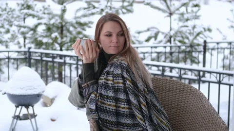 Woman drinking coffee with marshmallows while sitting on an armchair Stock Footage 157181416