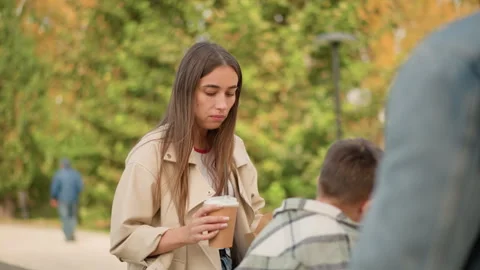 Woman drinking coffee while interacting with boy in park closeup showing outdoor Stock Footage 346722442