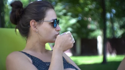 Woman drinking coffee while lying on sunbed. Stock Footage 94000460