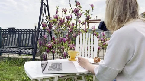 Woman Drinking Coffee While Working Remotely Outdoors in Spring Stock Footage 334572097