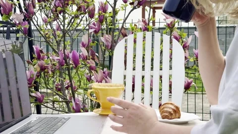 Woman Drinking Coffee While Working Remotely Outdoors in Spring Video stock 334572215