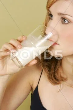A woman drinking a glass of milk. Stock Photos