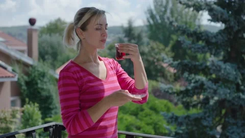 Woman is drinking a hot tea while watching the green view on the balcony. Stock Footage 140521648