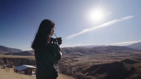 Woman drinking mate tea while overlooking mountain valley in northern Argentina Stock Footage 336763095