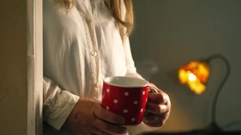 Woman drinking steaming hot coffee in doorway of home Stock Footage 312206853
