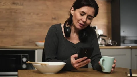 Woman Drinking Tea After Dinner And Surfing On Smartphone Stock Footage 339077897