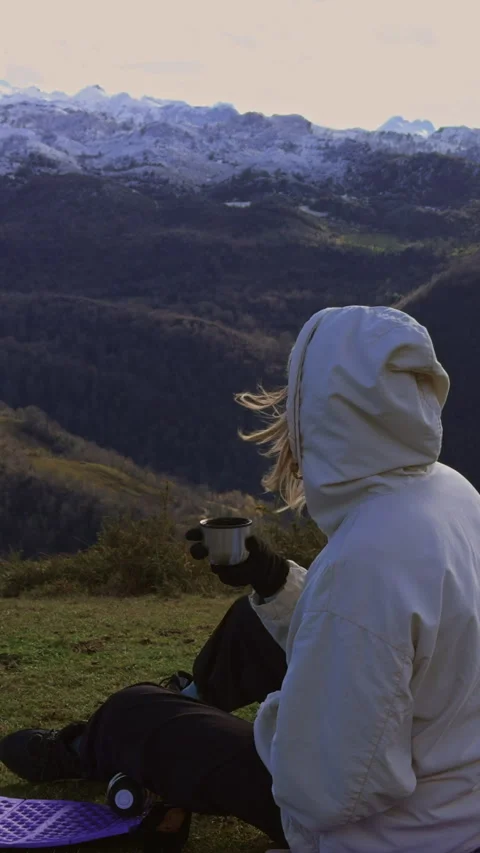 Woman drinking tea while enjoying panoramic mountain scenery. Stock-Footage 337652289