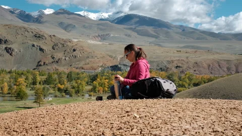 Woman Drinking Tea while Hiking around Mountains Vídeos de archivo 143145651