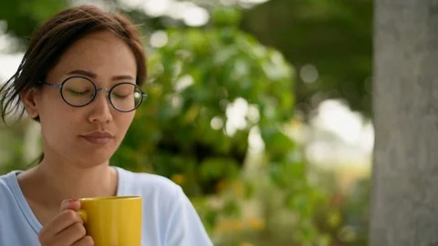Woman in drinking tea by the window at home Vidéo 87968849