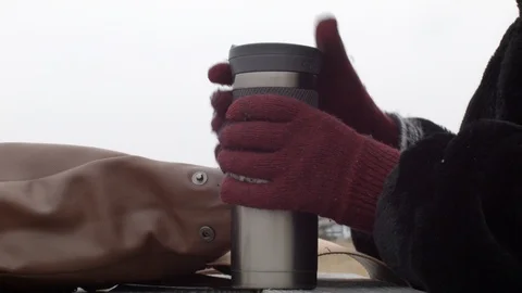Woman drinking from a travel mug in cold winter Stock Footage