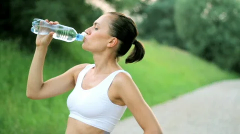 Woman drinking water after sport activities, slow motion Stock Footage