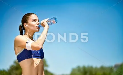 Woman drinking water after sport activities Stock Photos