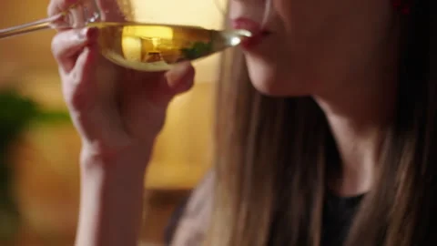 Woman drinking white wine on sofa by candlelight at home Stock Footage 329010723