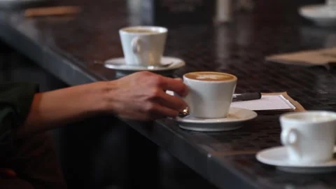 Woman drinks coffee while waiter hand puts the bill on the table in the cafe. Video stock 313815148