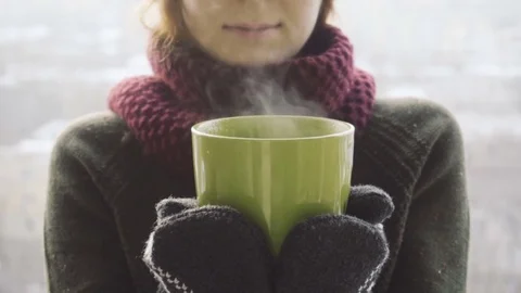 Woman drinks hot tea or coffee from green cup on winter morning Stock Footage 85048874